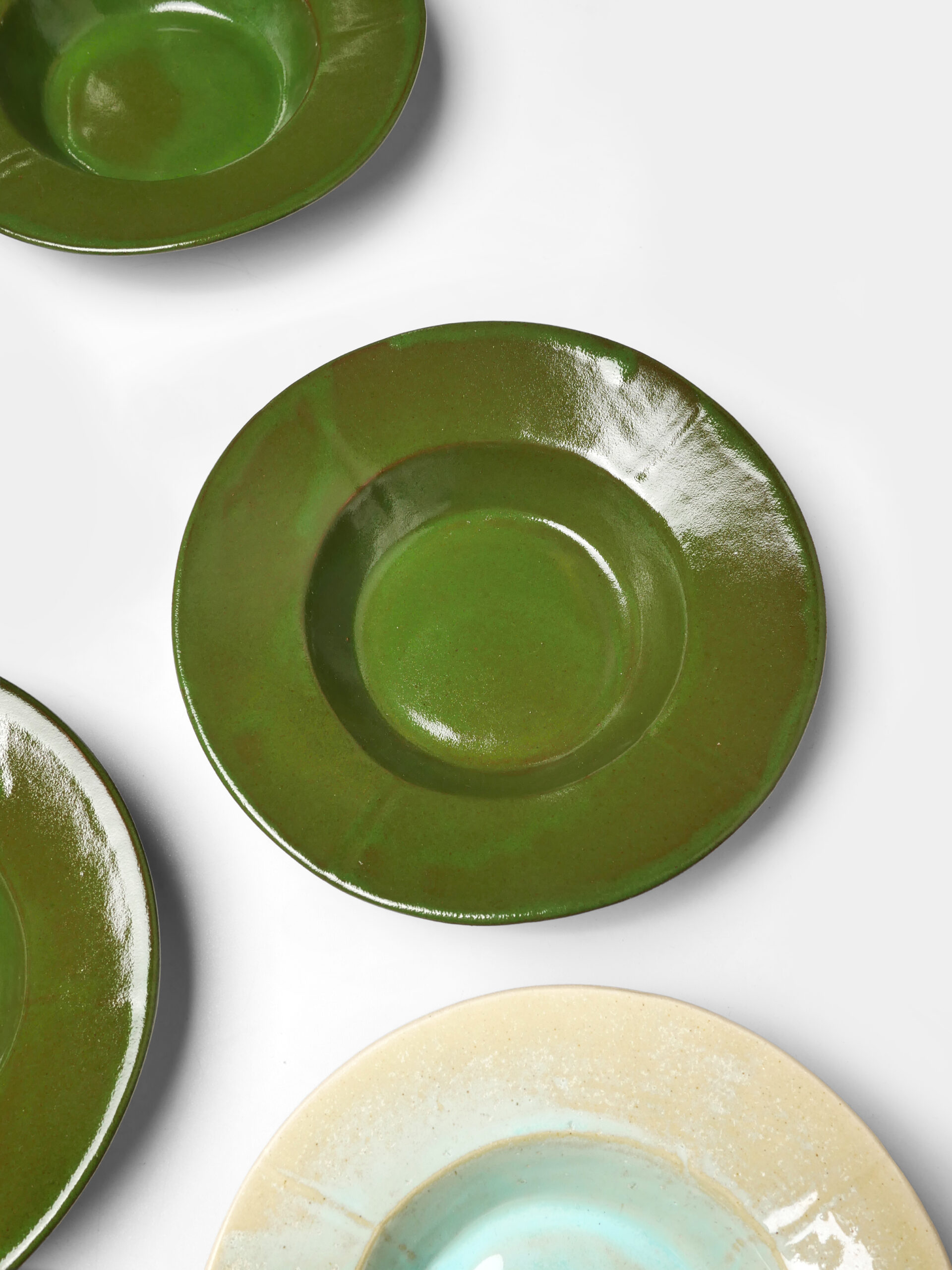 Assiette creuse artisanale en grès émaillé couleur vert amazone, fabriquée à la main dans un atelier parisien